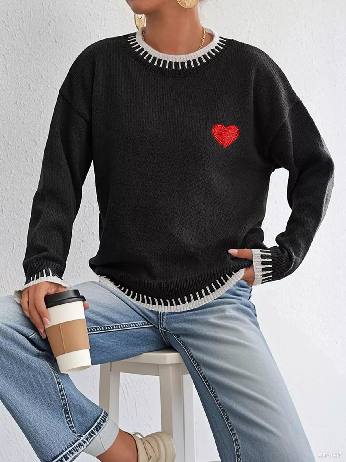 Heart-embroidered contrast-trim sweater in black, seated view