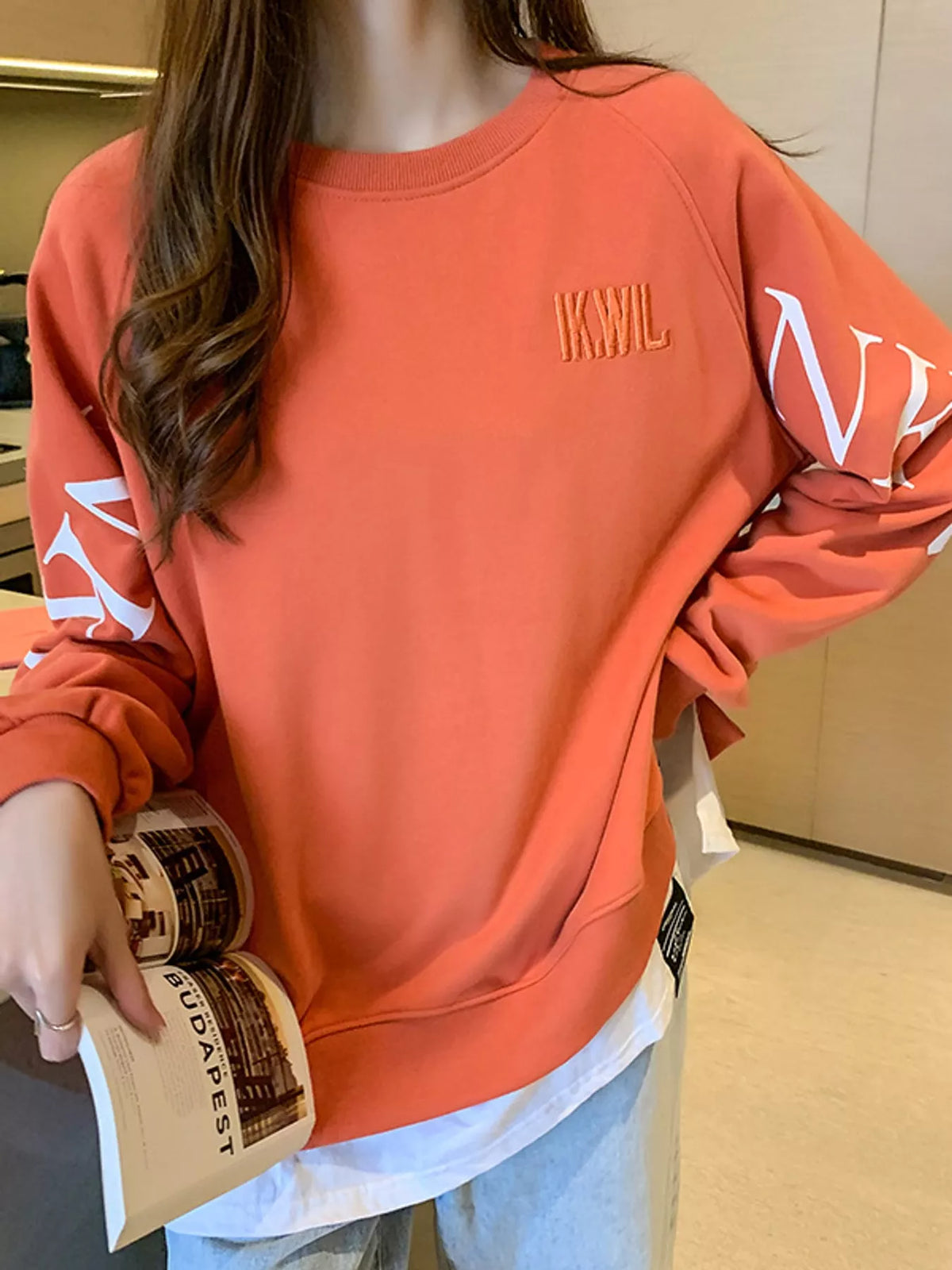 Orange layered-hem sweatshirt with graphic sleeve detail