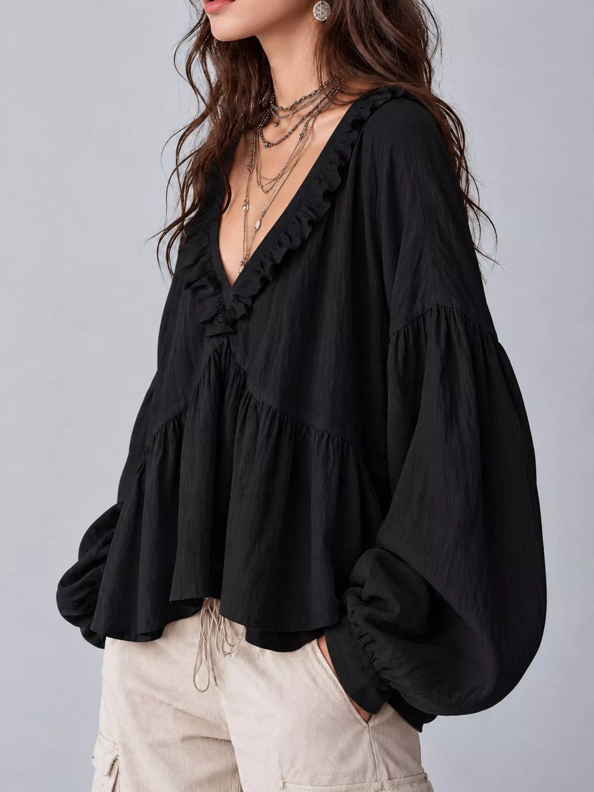 Black ruffled v neck blouse, side view