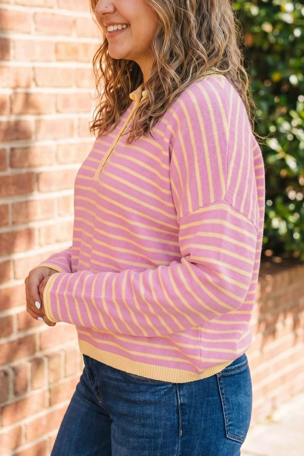 Pink and yellow striped button-detail sweater, side view