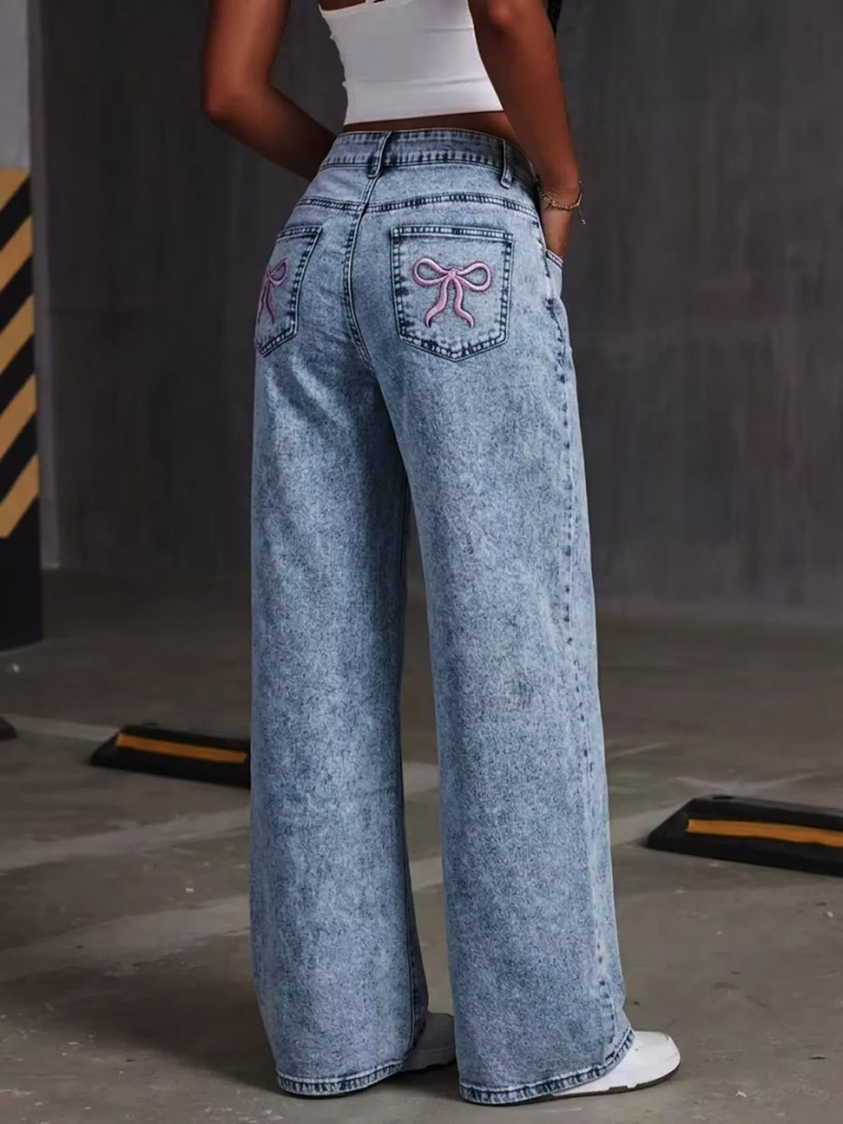 Blue bow-embroidered wide-leg jeans, full back view.