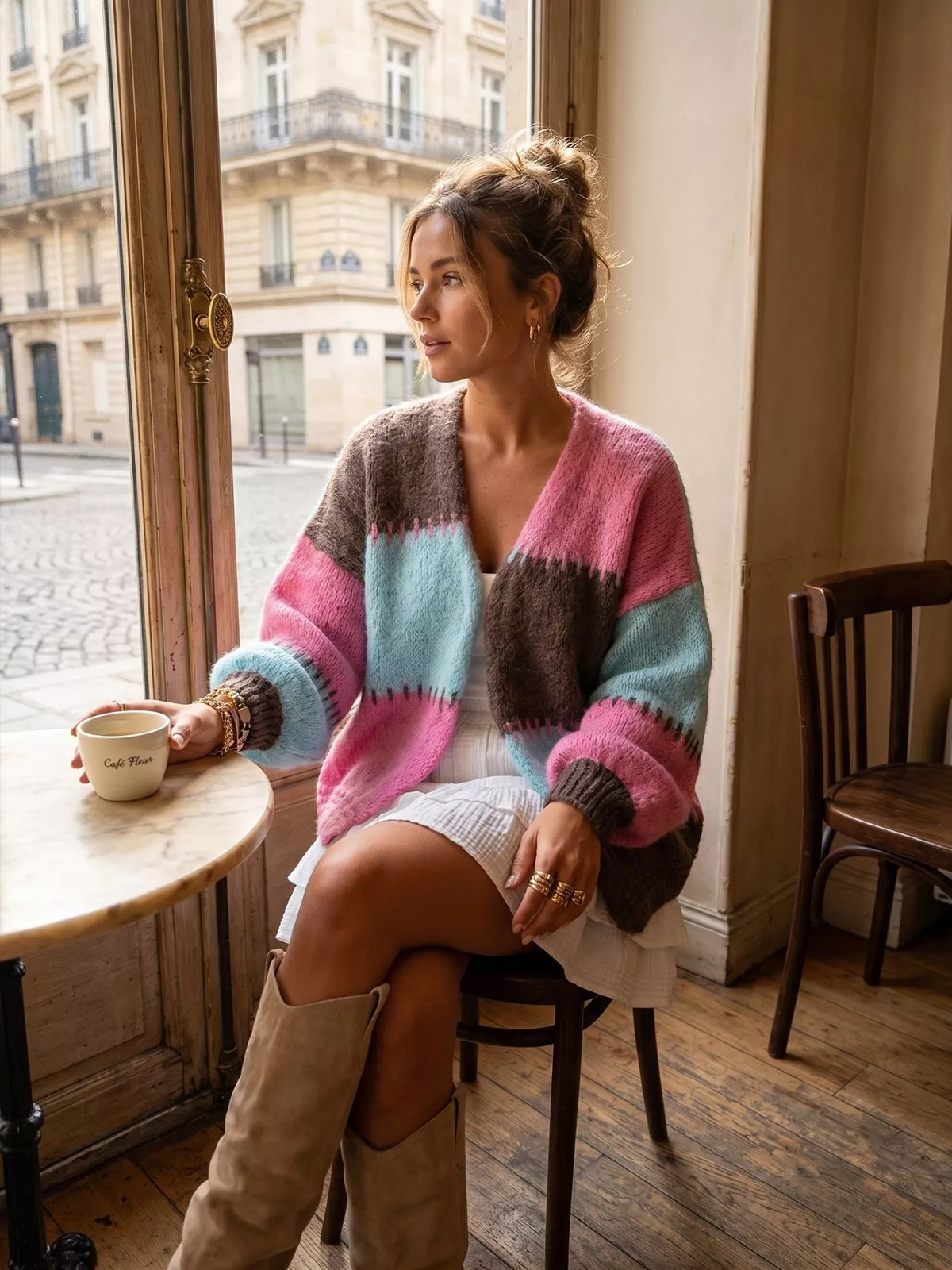 Pink and blue color-block v-neck cardigan, seated front view.