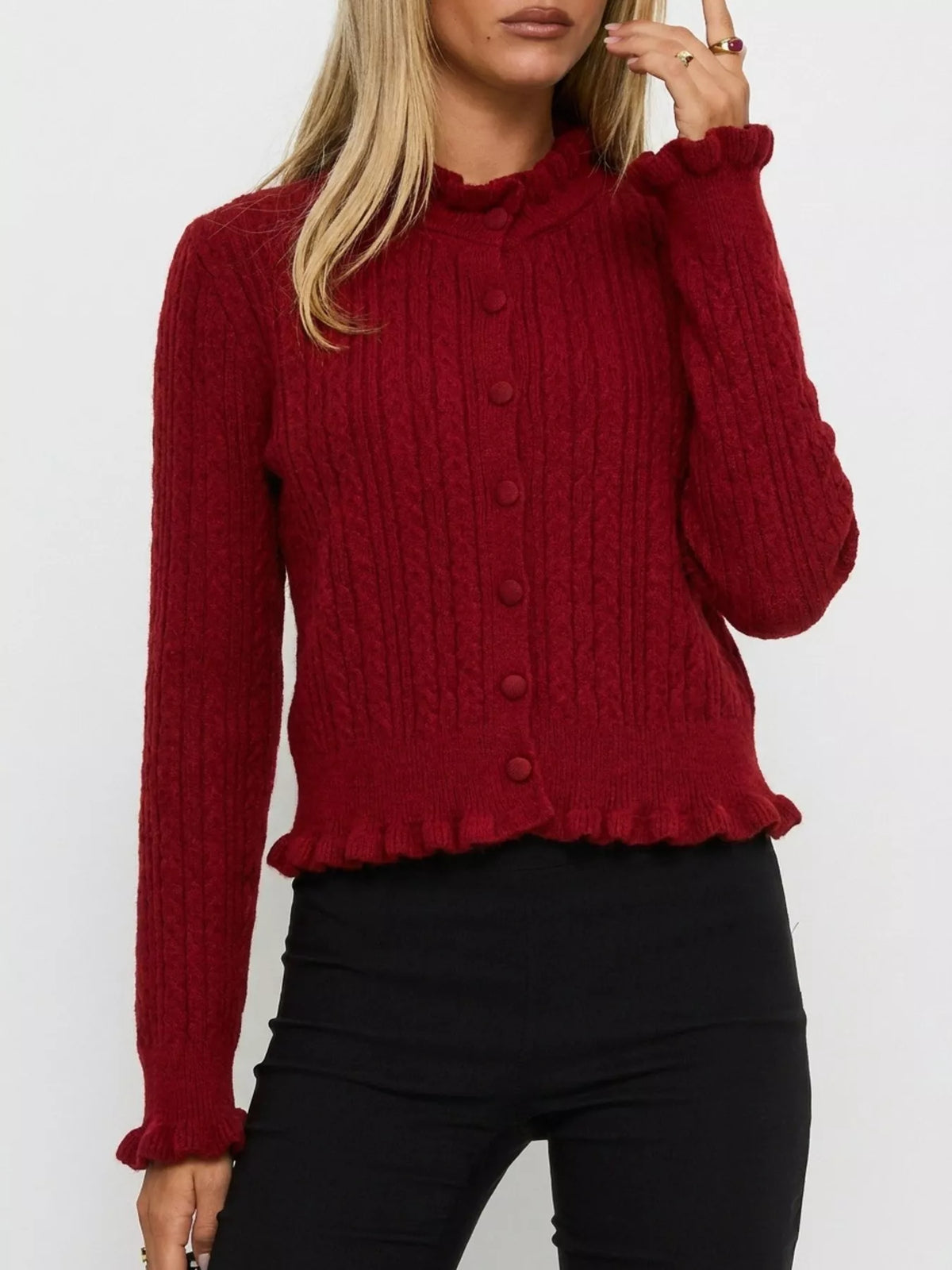 Burgundy cable-knit ruffle-trim cardigan, front showing ruffled cuffs.