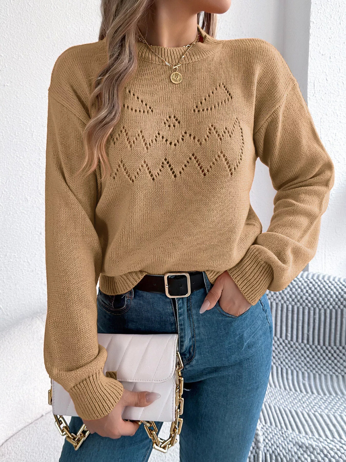 Camel halloween pumpkin face knit sweater, front with handbag.