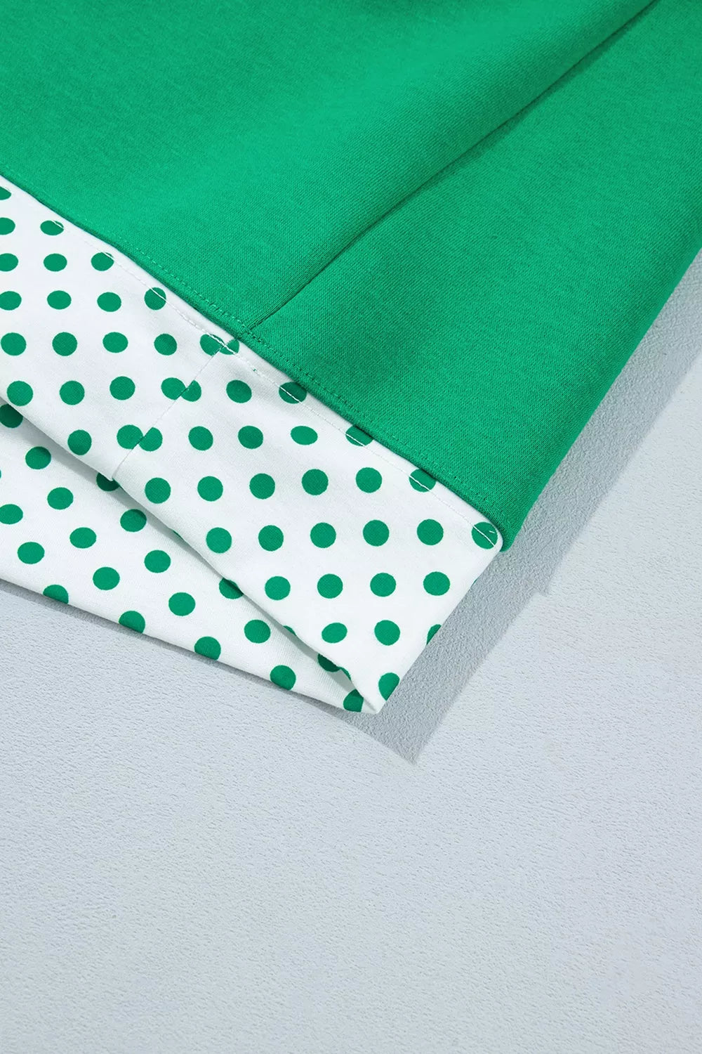 Green sweatshirt and shorts set with polka-dot trim, hem detail