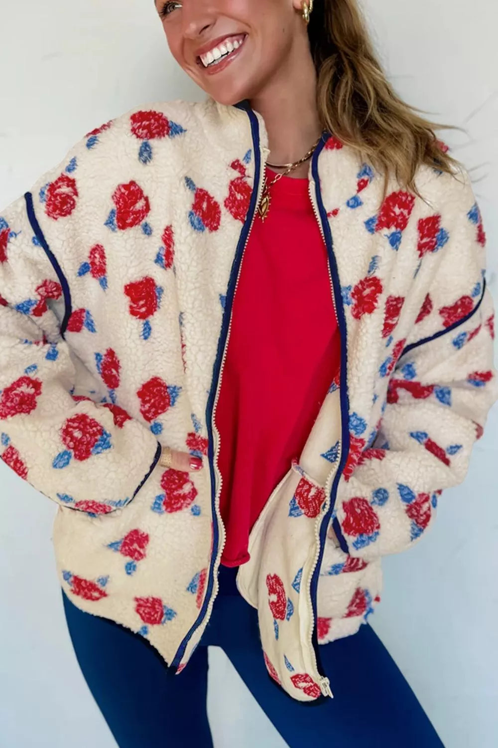 Cream with red flowers floral zip-up fleece jacket, angled front view.