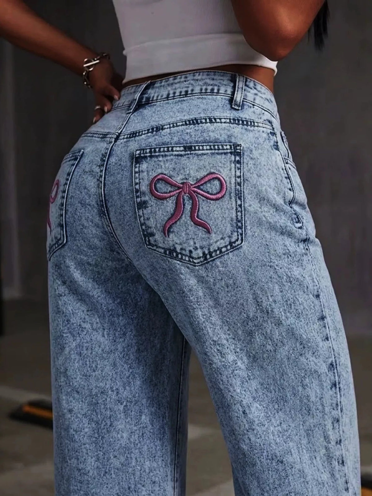 Blue bow-embroidered wide-leg jeans, embroidered bow back-pocket detail.