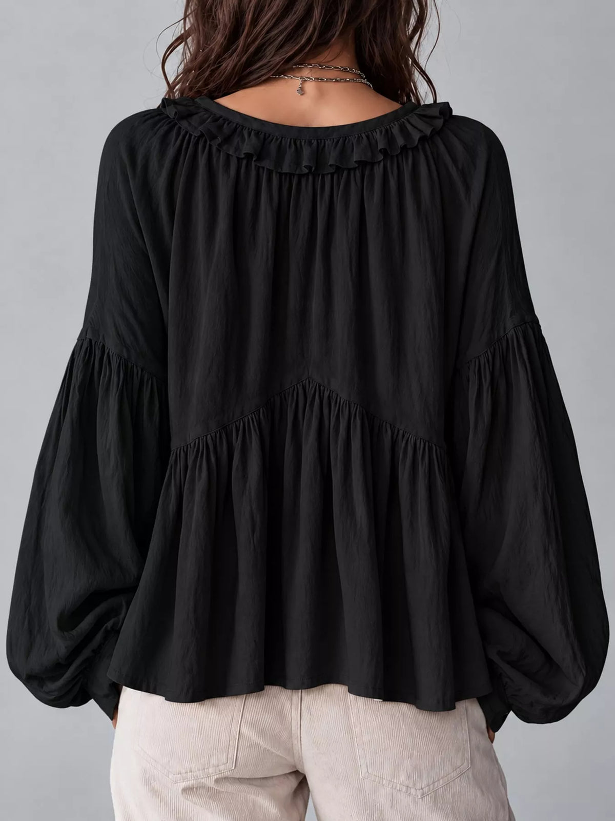Black ruffled v neck blouse, back view