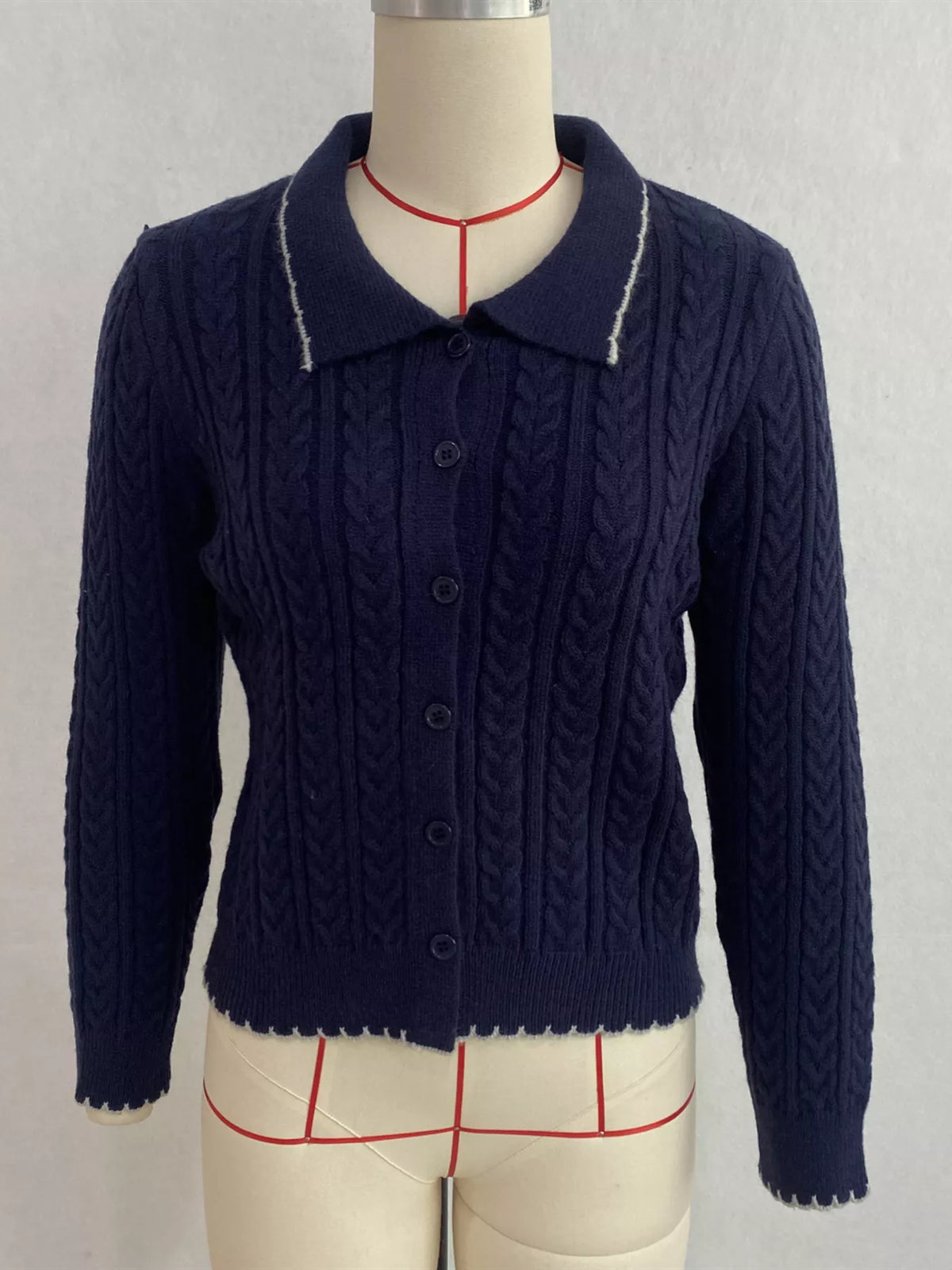 Navy cable-knit polo-collar cardigan, front on dress form.