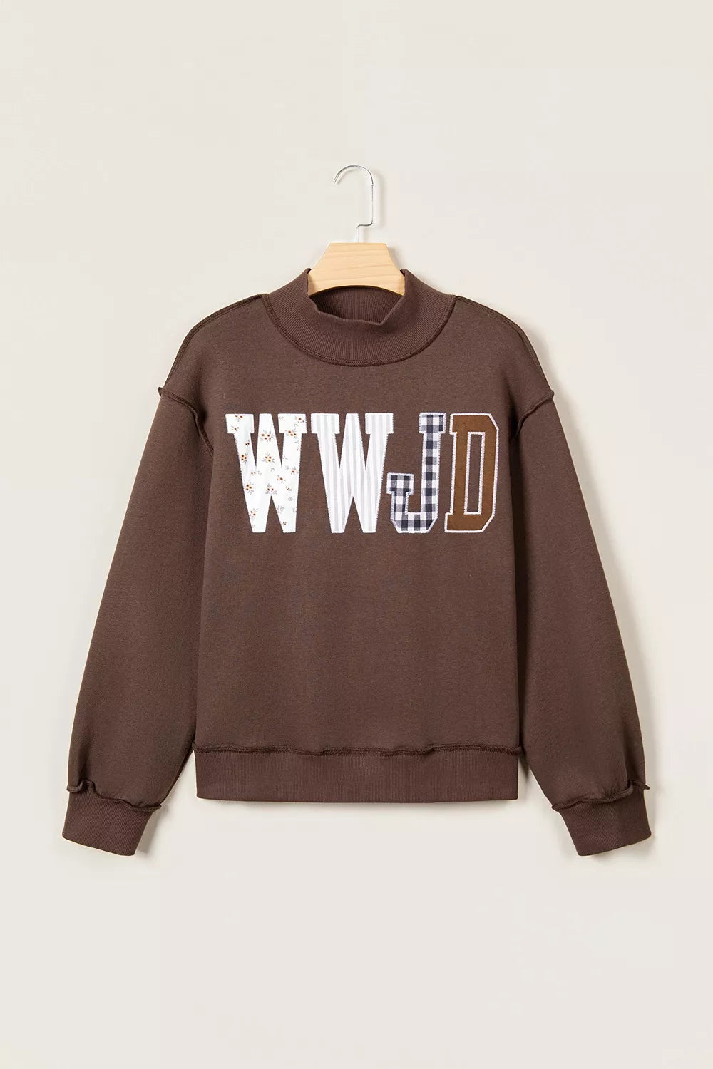 Brown wwjd patchwork graphic mock-neck sweatshirt, front on hanger.