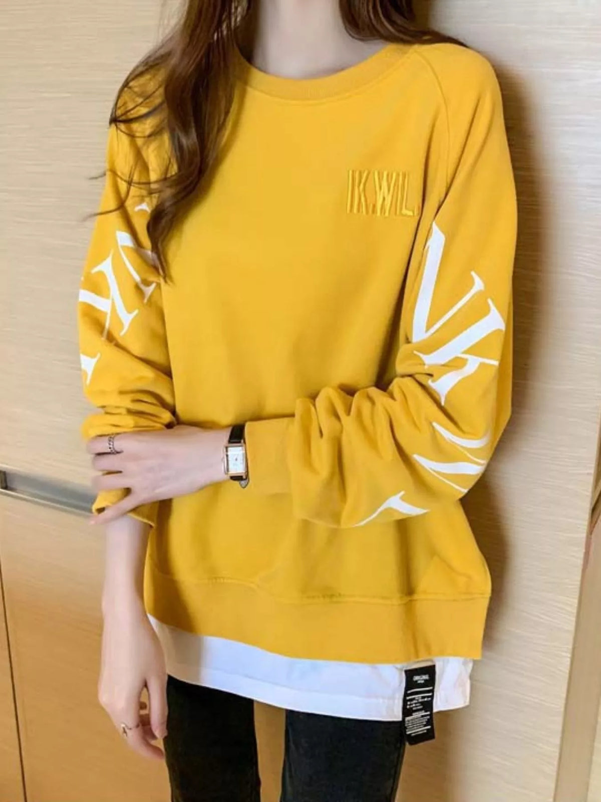 Yellow layered-hem sweatshirt with graphic sleeve detail, back view