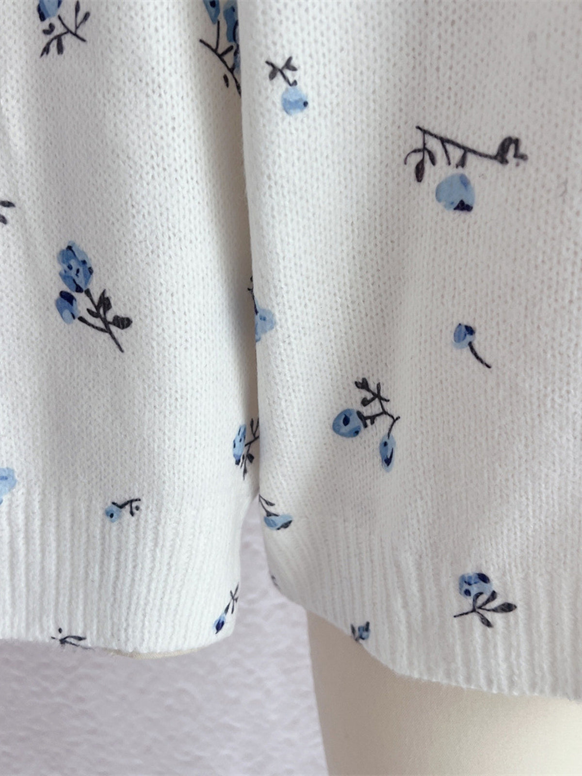 White floral dropped-shoulder oversized sweater, floral knit close-up.