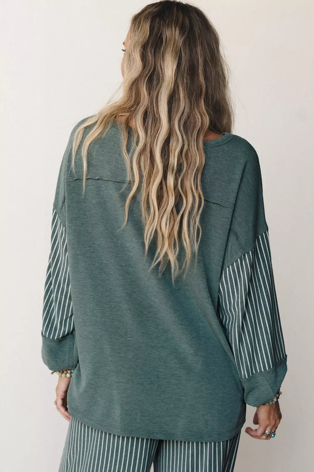 Green raw-seam top and striped pants set, back of top