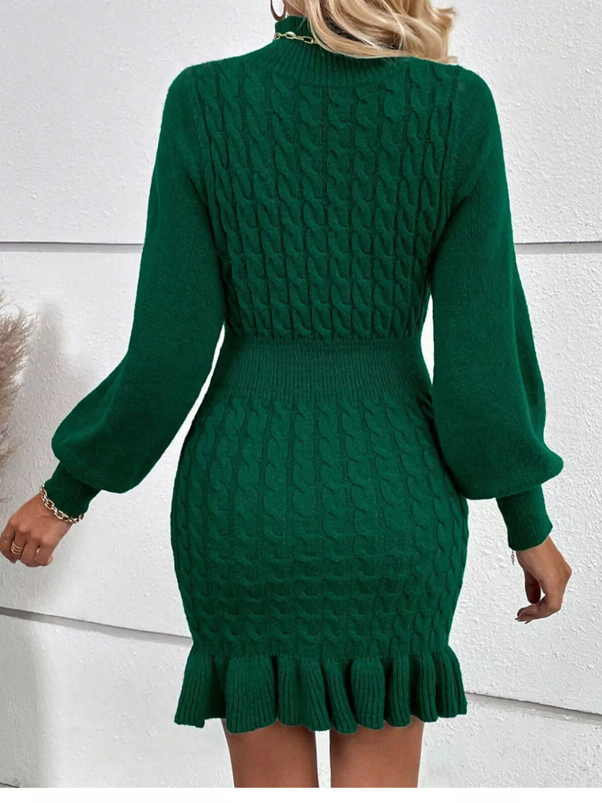 Green cable-knit ruffle-hem sweater dress, back view.