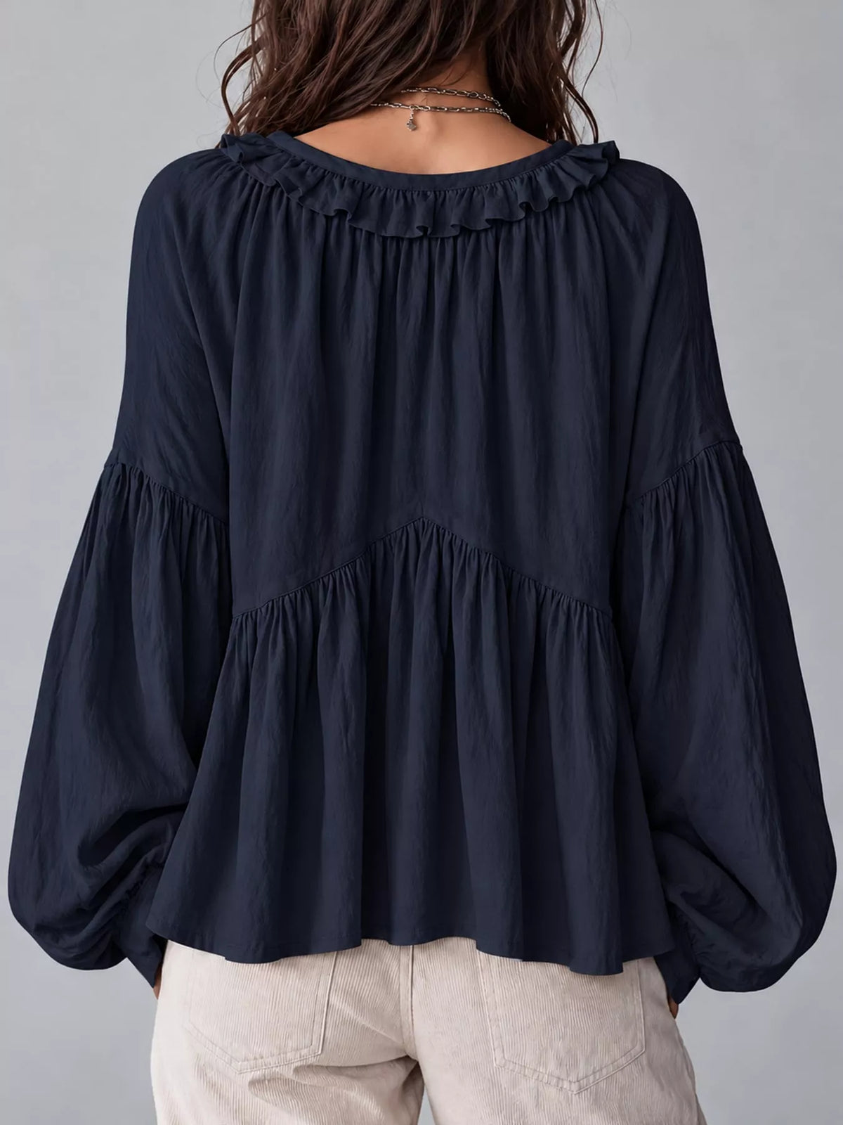 Navy blue ruffled v neck blouse, back view