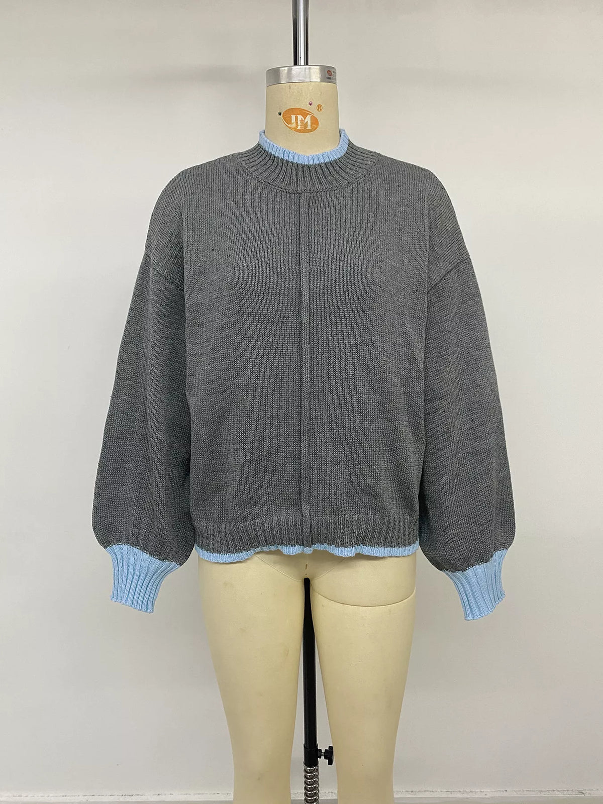 Gray sweater with blue contrast trim, front on mannequin