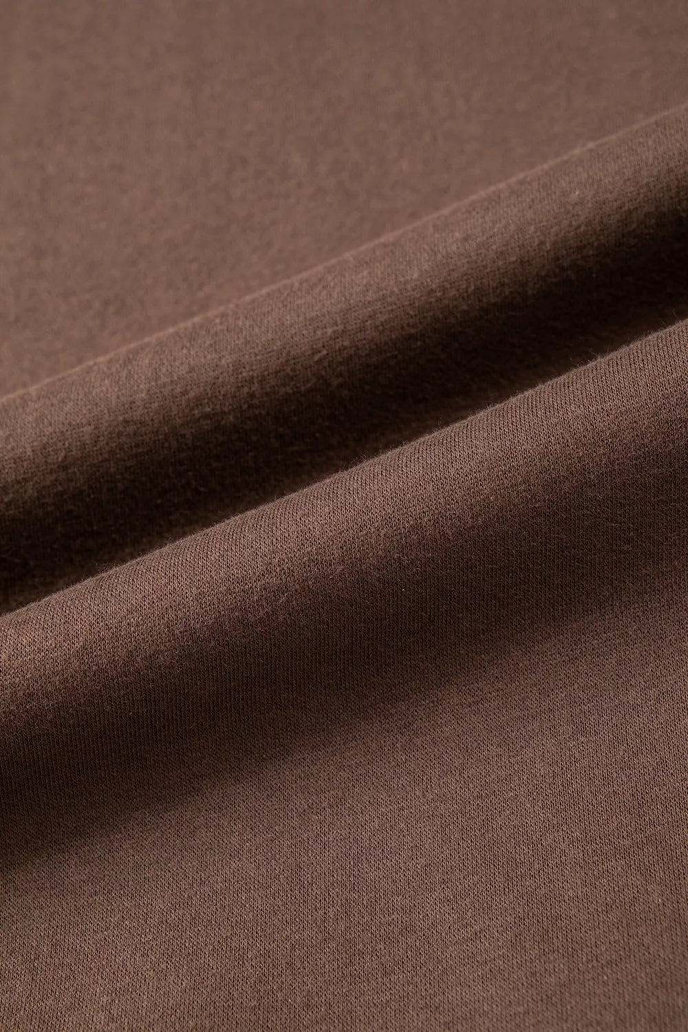 Brown wwjd patchwork graphic mock-neck sweatshirt, outer fabric close-up.