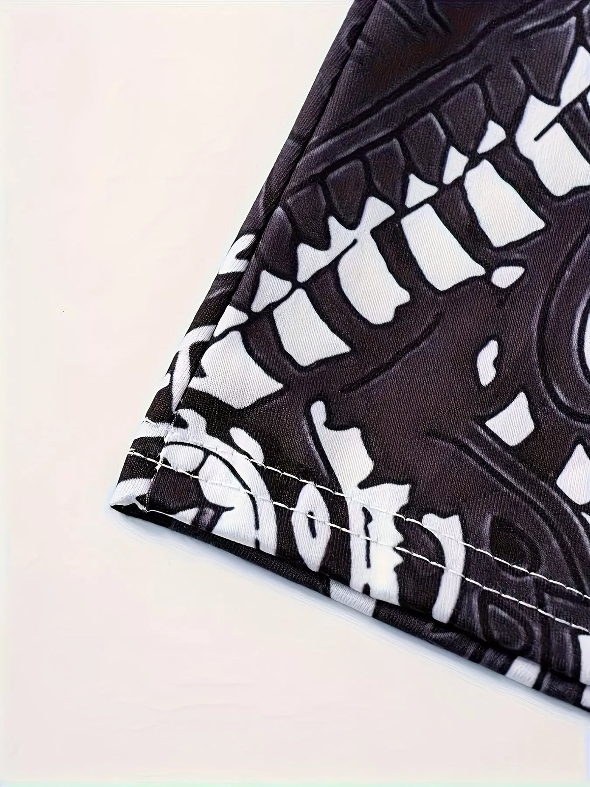 Black and white printed spaghetti strap maxi dress, close-up of the printed hem stitching