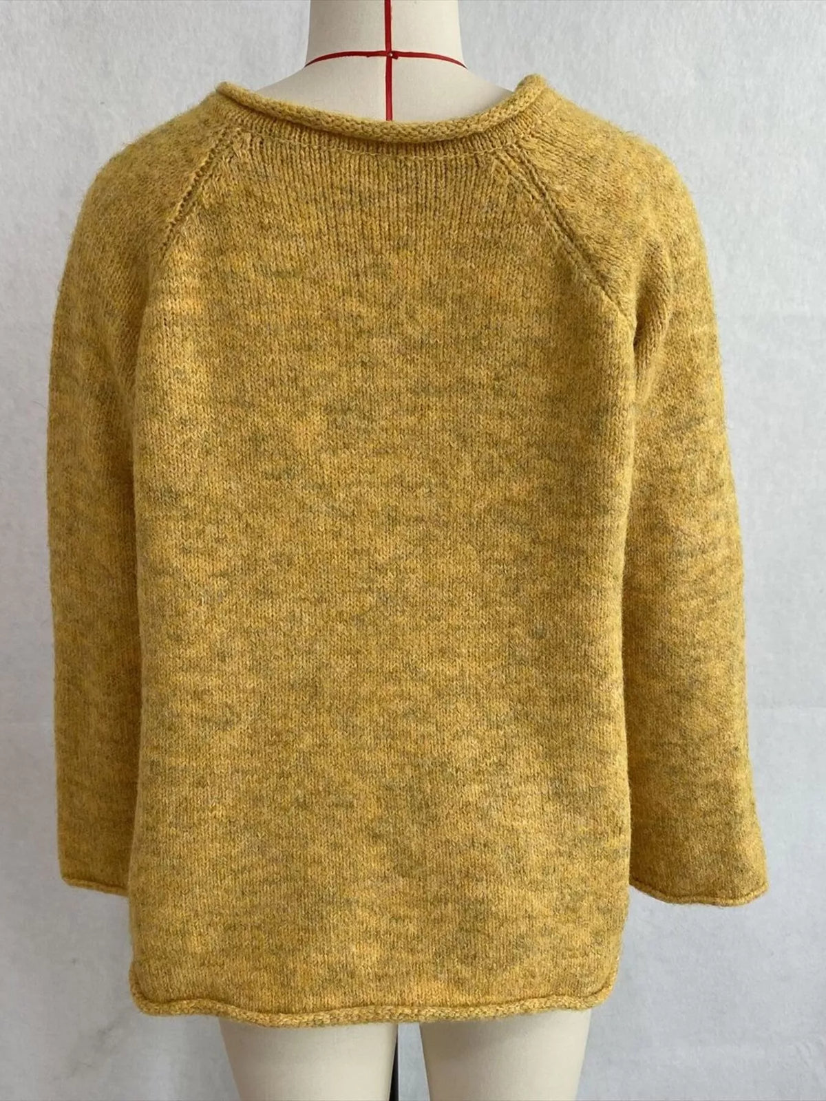 Yellow v-neck knit top with polka dot ribbon tie, back on dress form.