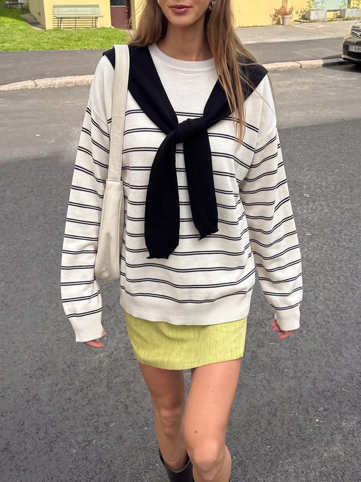 Striped crewneck sweater with layered tie detail in white and black, front view on model
