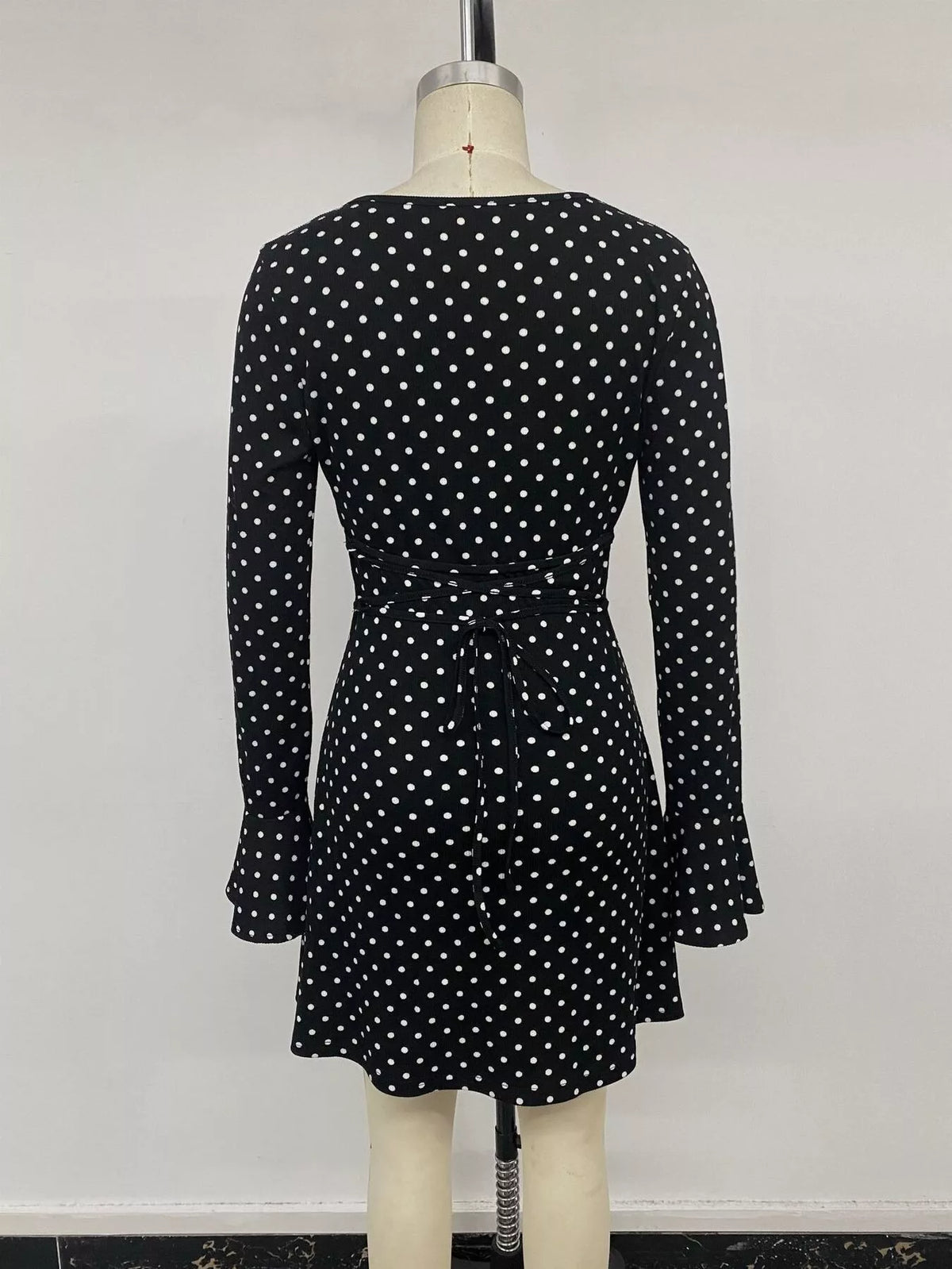 Black polka dot flounce sleeve mini dress, back on mannequin