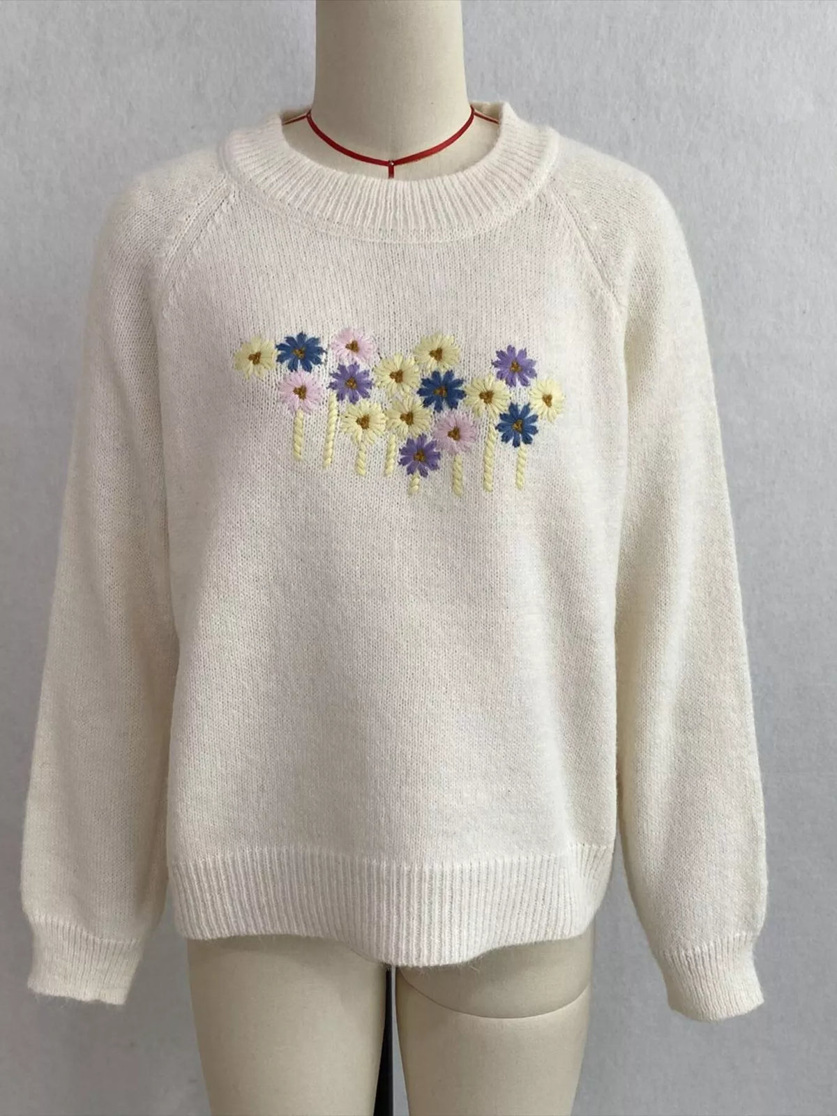 Floral embroidered round-neck sweater in white, front mannequin view