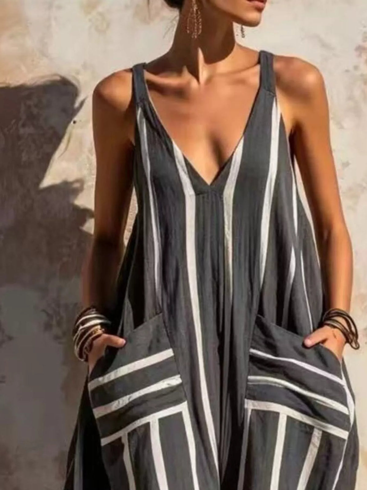 Black and white striped sleeveless jumpsuit, neckline and pockets detail