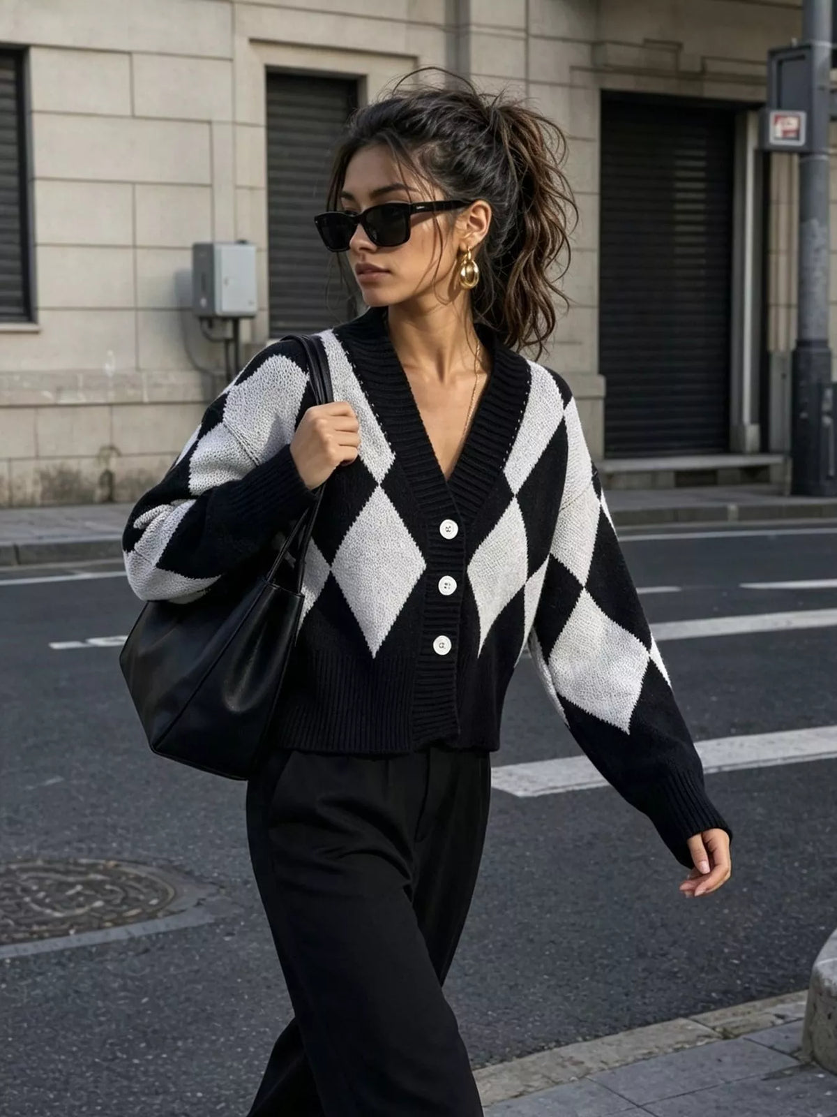 Black and white argyle v-neck button-front cardigan, walking front view.