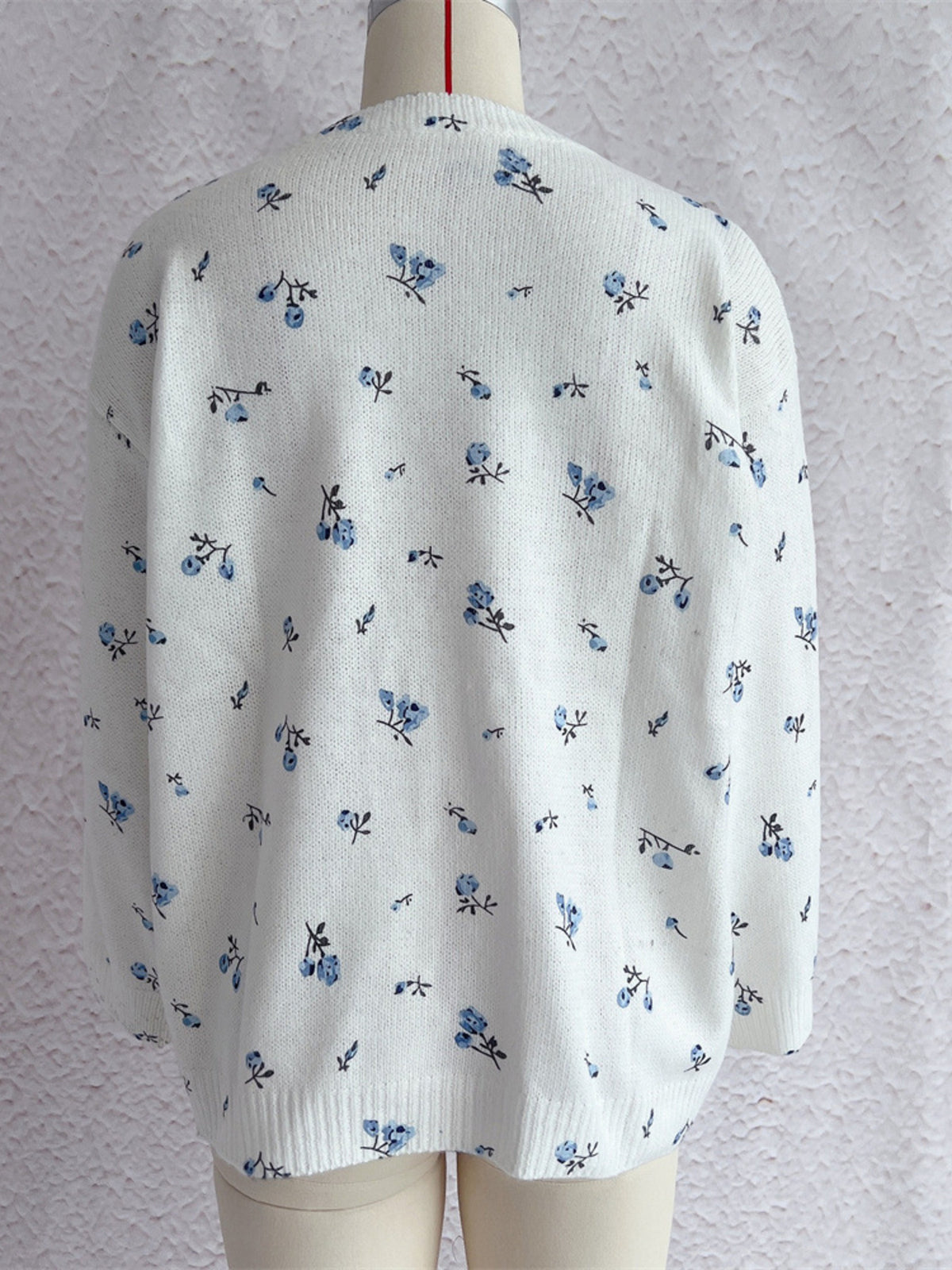 White floral dropped-shoulder oversized sweater, back on dress form.