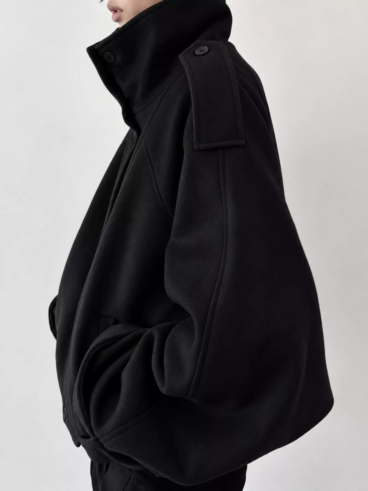 Black zip-up stand-collar jacket — side view