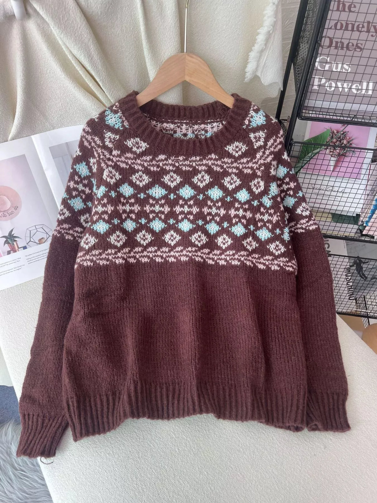Brown fair isle round-neck sweater, front on hanger.
