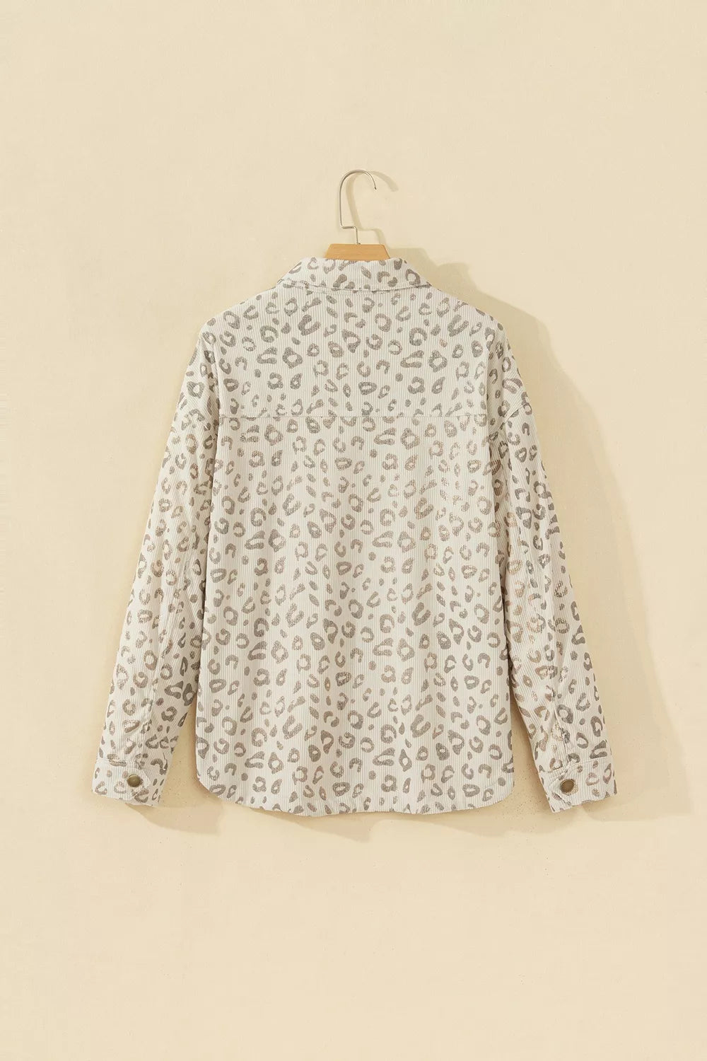 Beige leopard corduroy button-front jacket, back on hanger.