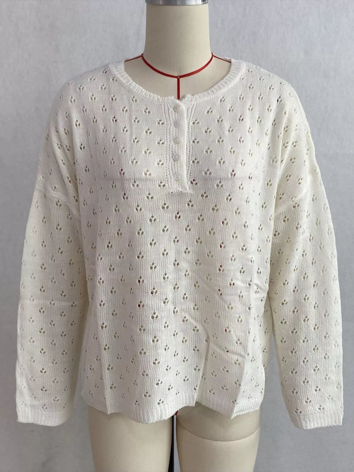 White pointelle round-neck knit top, front on dress form.