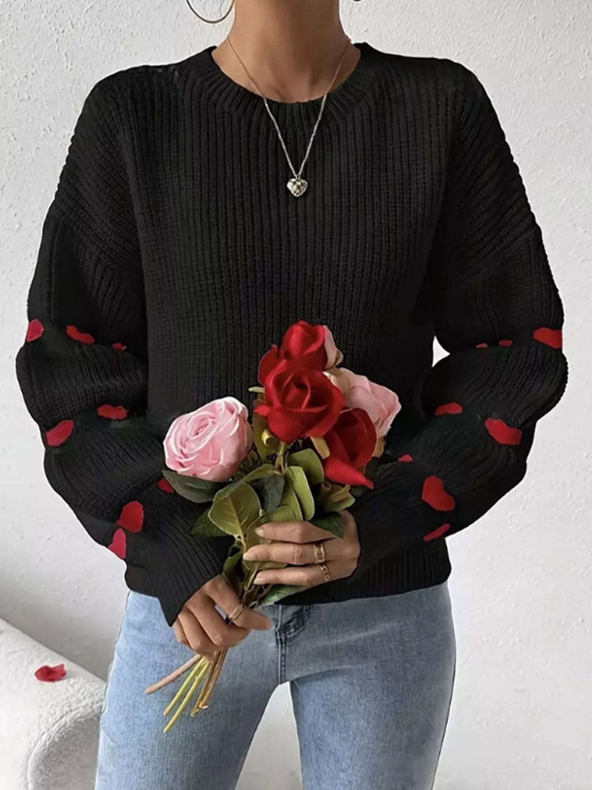 Black and red heart-sleeve dropped-shoulder sweater, front view.