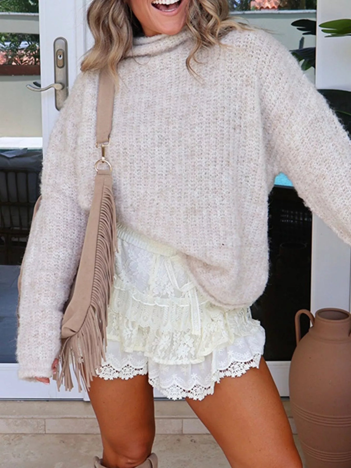 Cream mock-neck chunky-knit sweater, front view with hem tucked