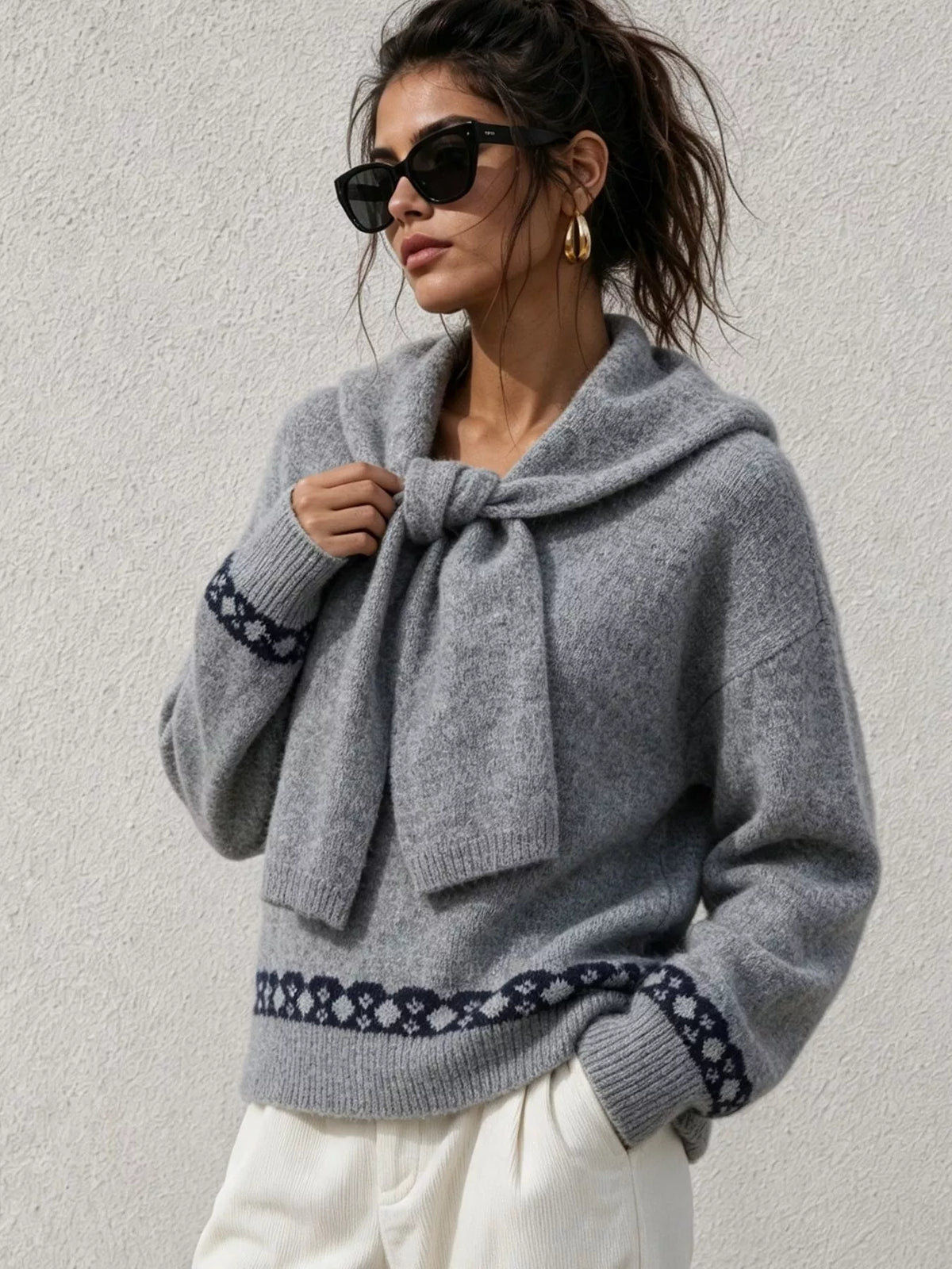 Gray scarf-detail dropped-shoulder sweater, front with hand at scarf.