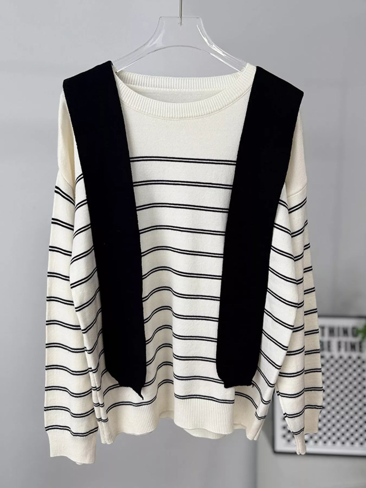 Striped crewneck sweater with layered tie detail in white and black, hanging front view with ties
