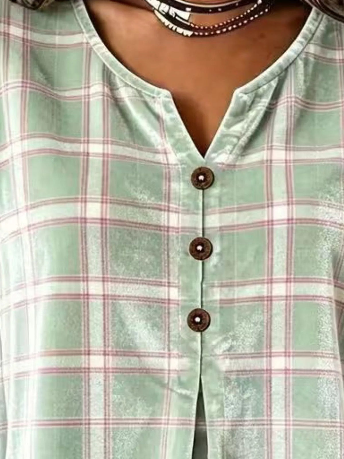 Green plaid velvet balloon-sleeve blouse, neckline and buttons close-up