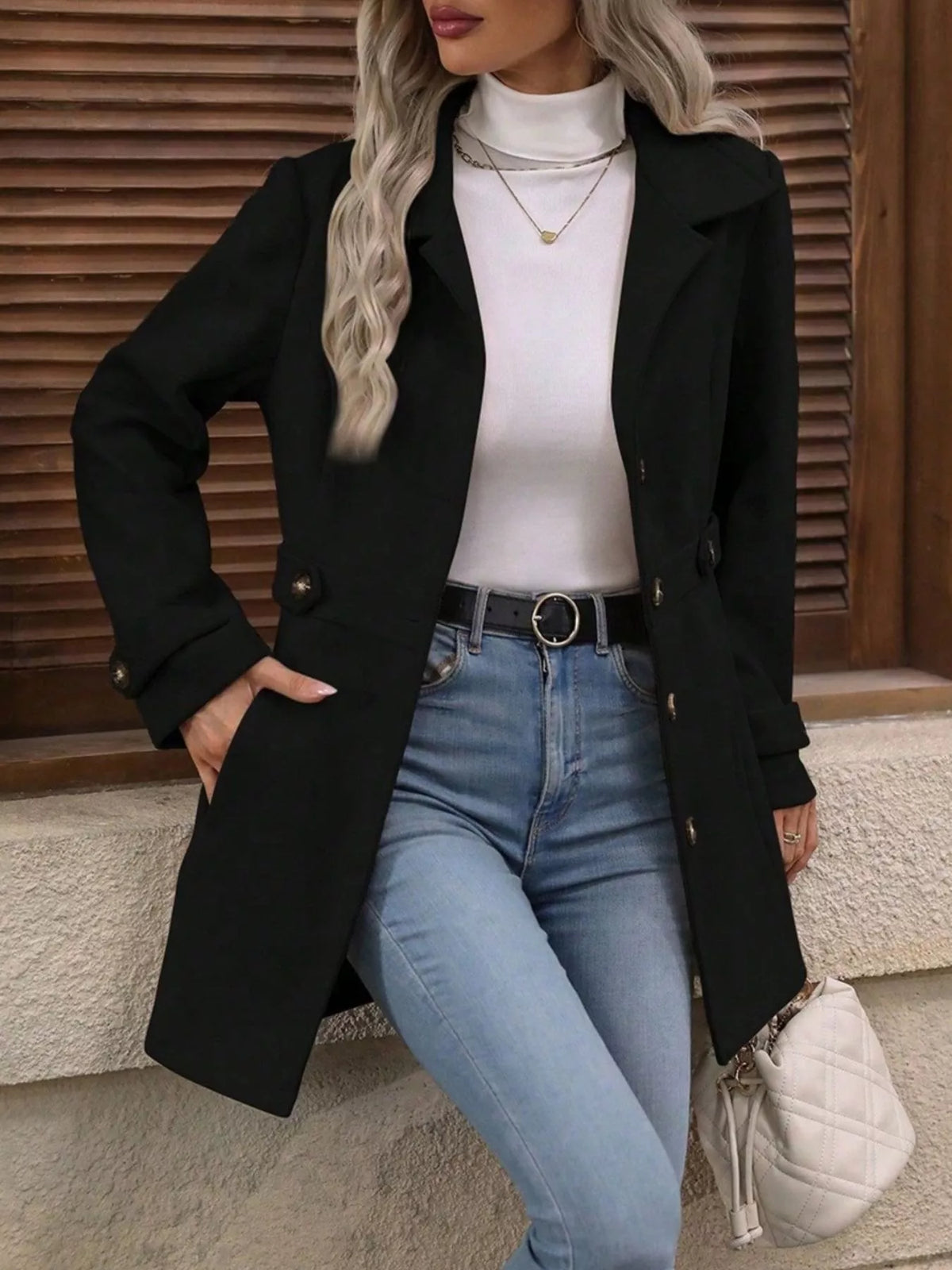 Black single-breasted coat, open front view with hand at hip