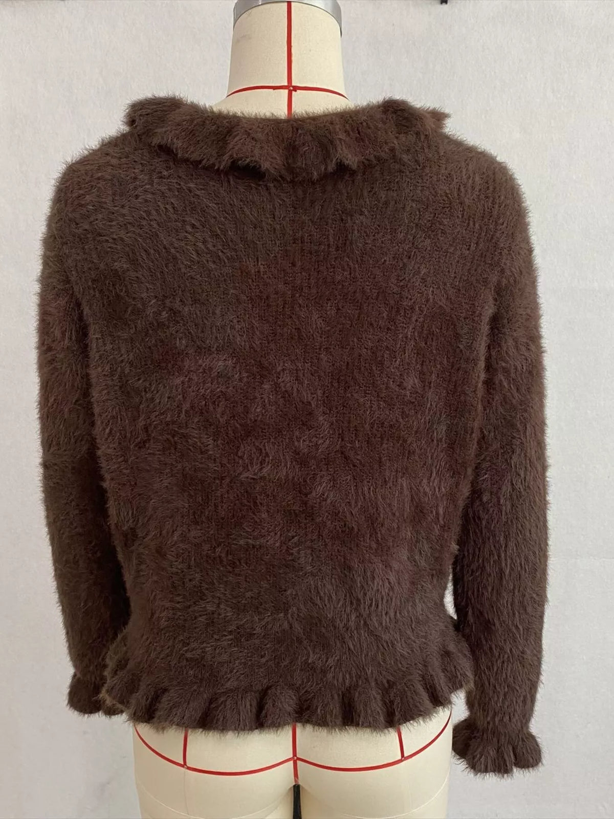 Brown fuzzy ruffle-trim button-front cardigan, back on dress form.