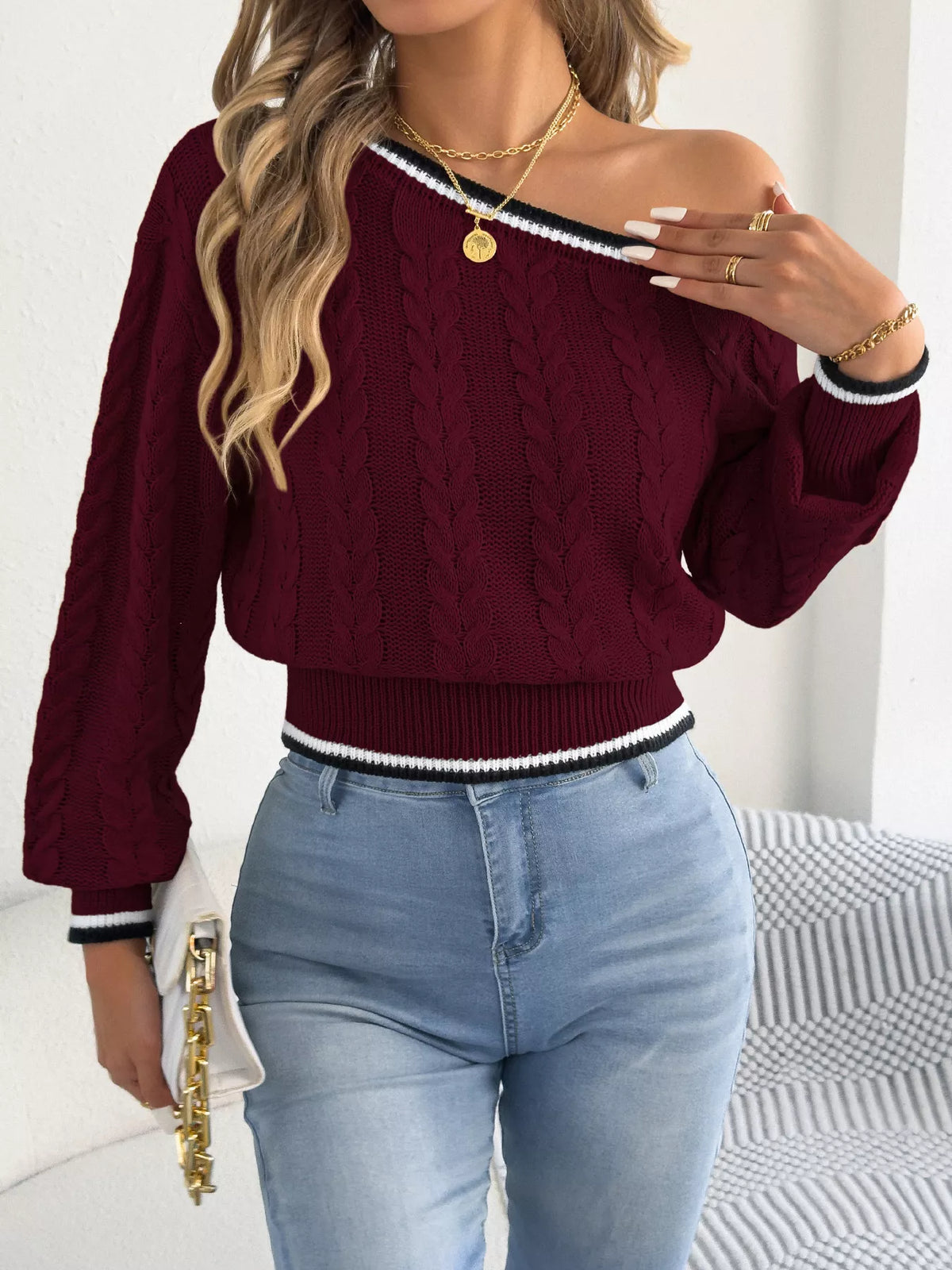 Orange one-shoulder cable knit sweater with striped trim