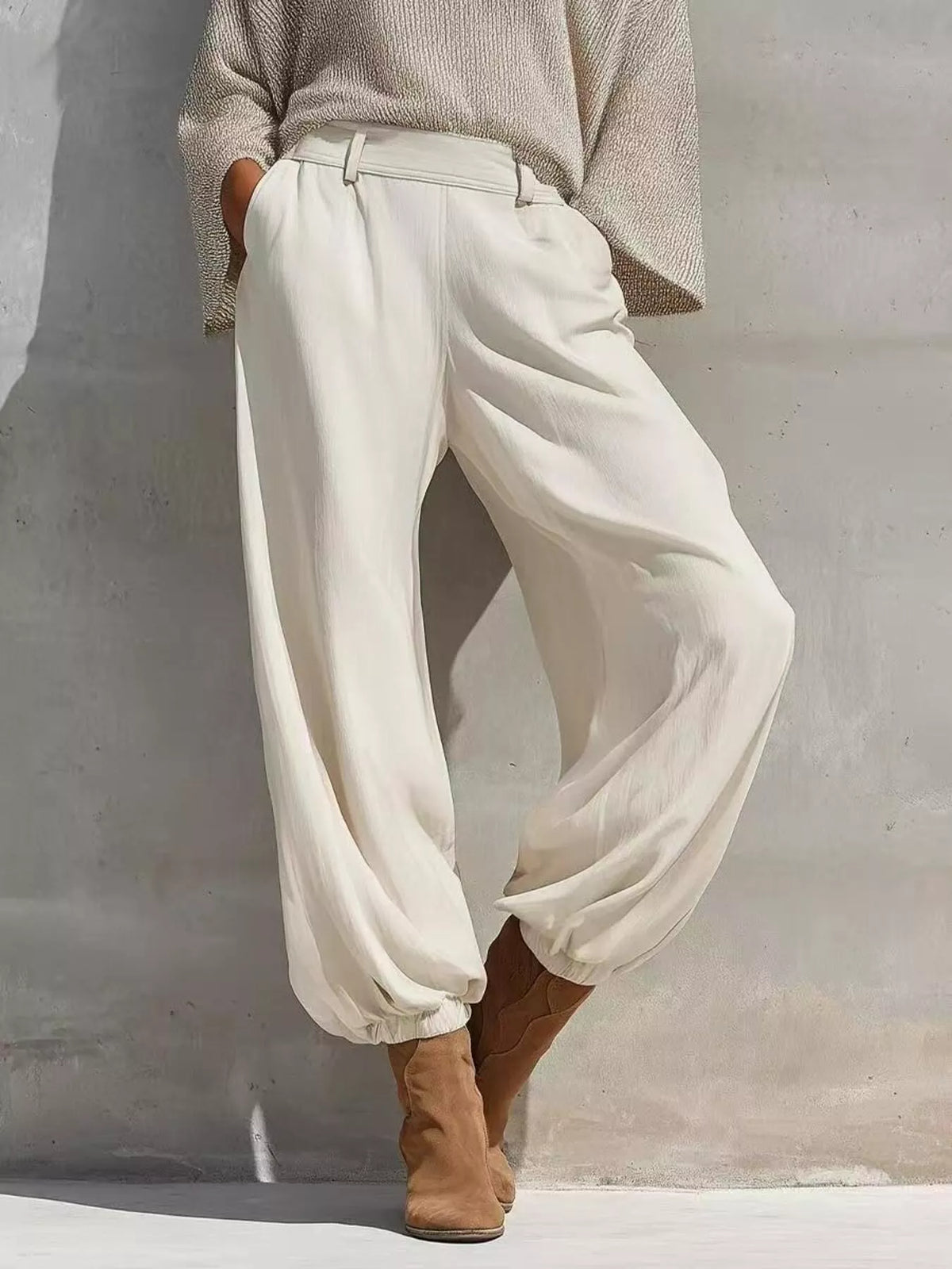 Beige one-shoulder knit top and pants set, white pants front view.