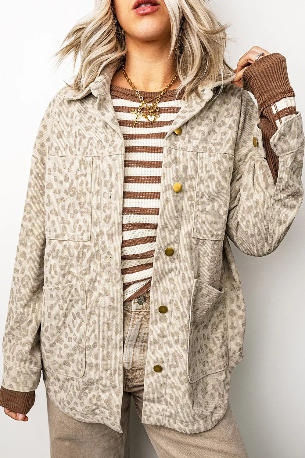 Beige leopard corduroy button-front jacket, front view with raised hand.