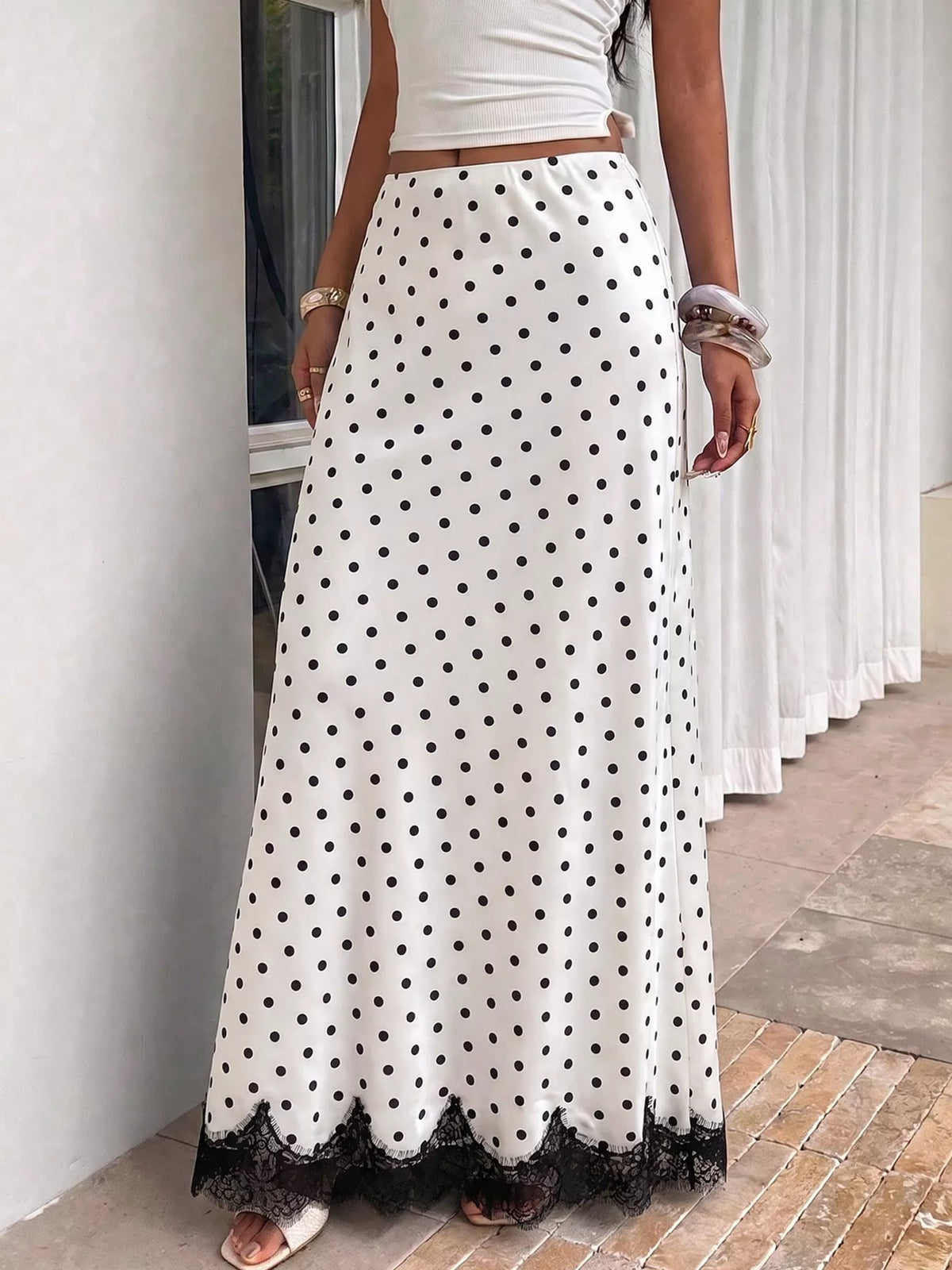 White and black polka dot high-waisted maxi skirt with black lace hem