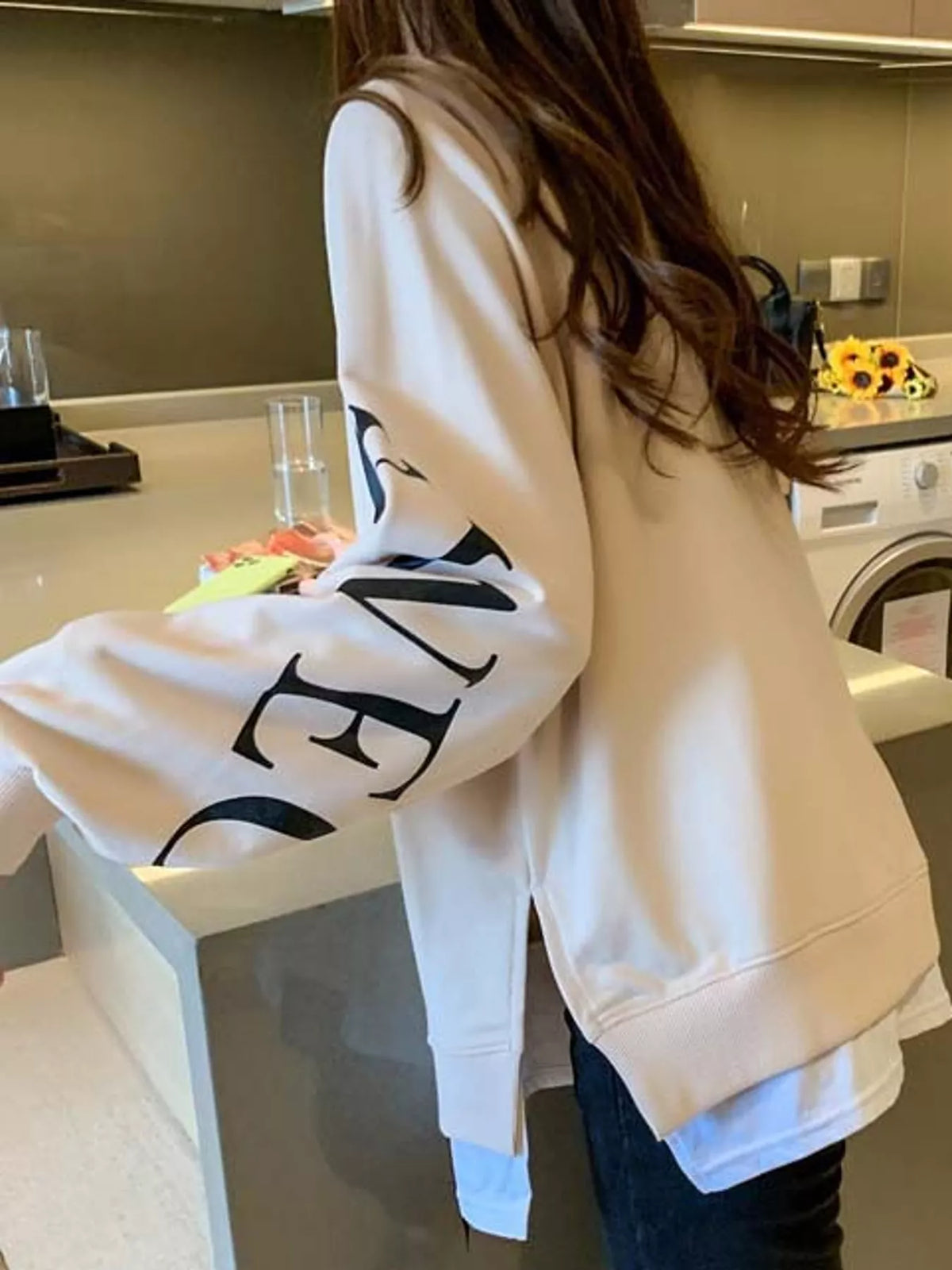Apricot layered-hem sweatshirt with graphic sleeve detail, back view