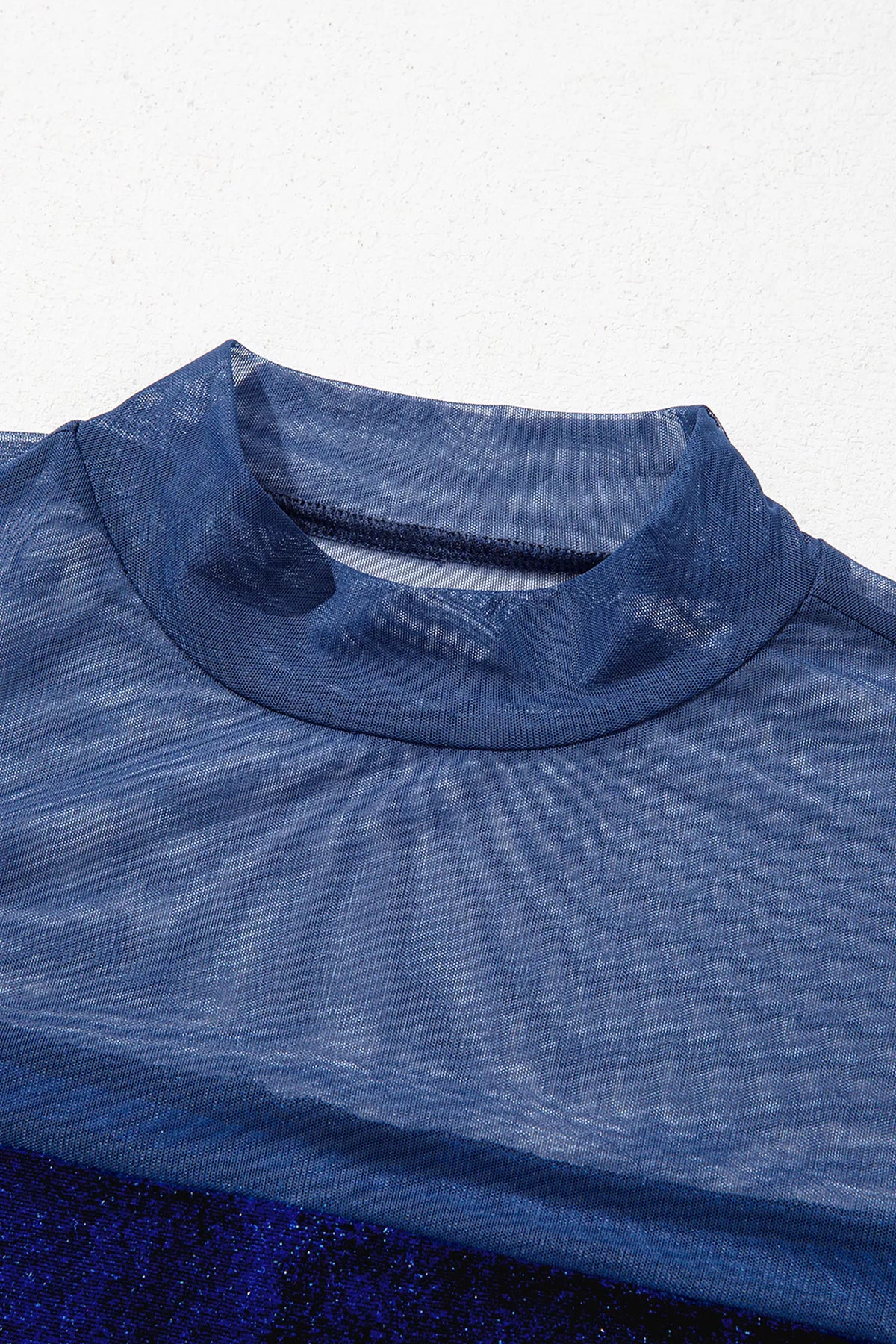 Navy velvet top with sheer yoke and long sleeves, sheer neckline close-up.