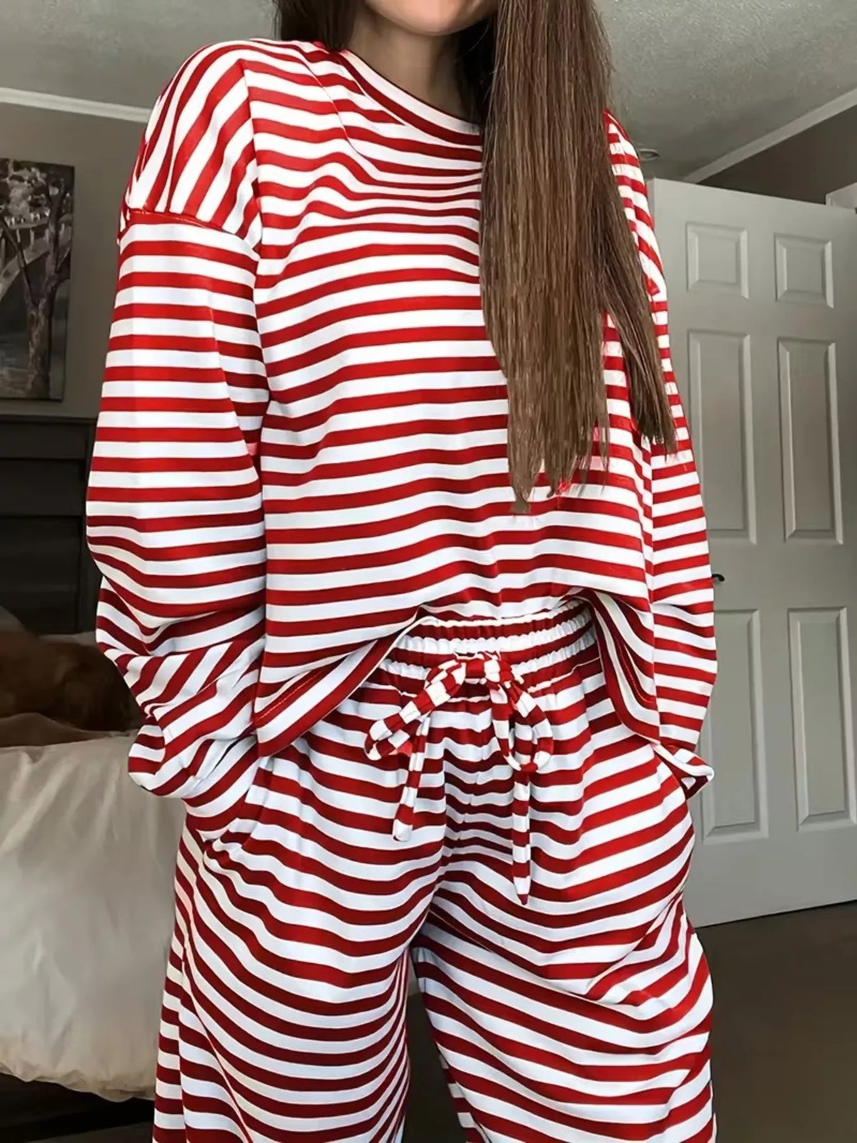 Red striped long-sleeve top and pants set, front detail with both hands in pants pockets