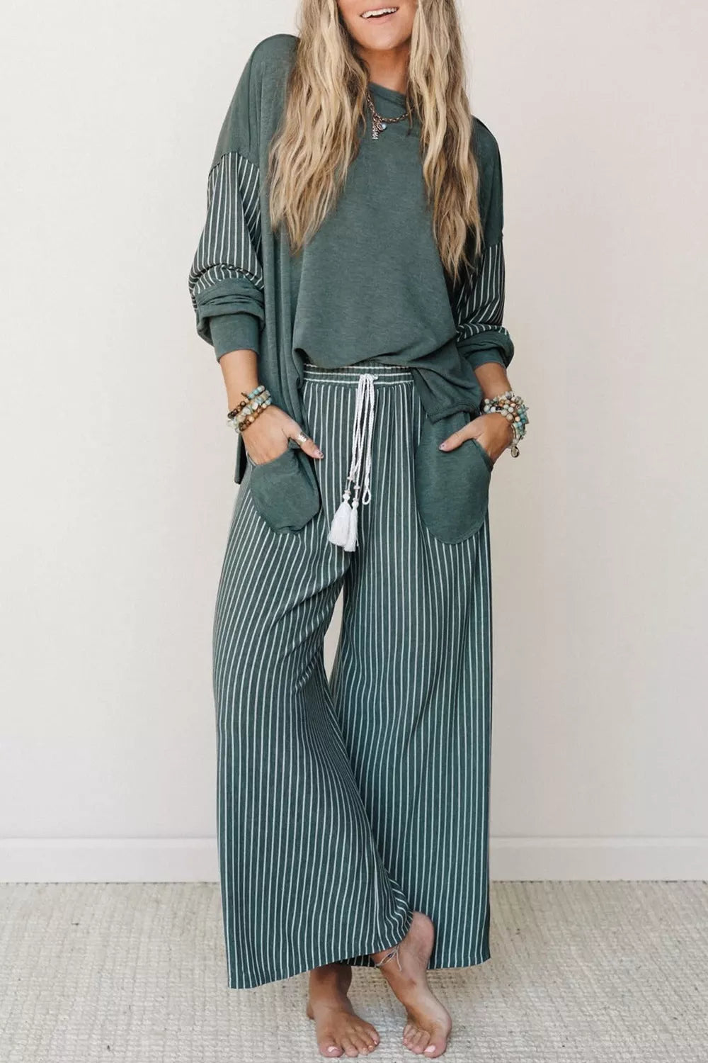 Green raw-seam top and striped pants set, front view