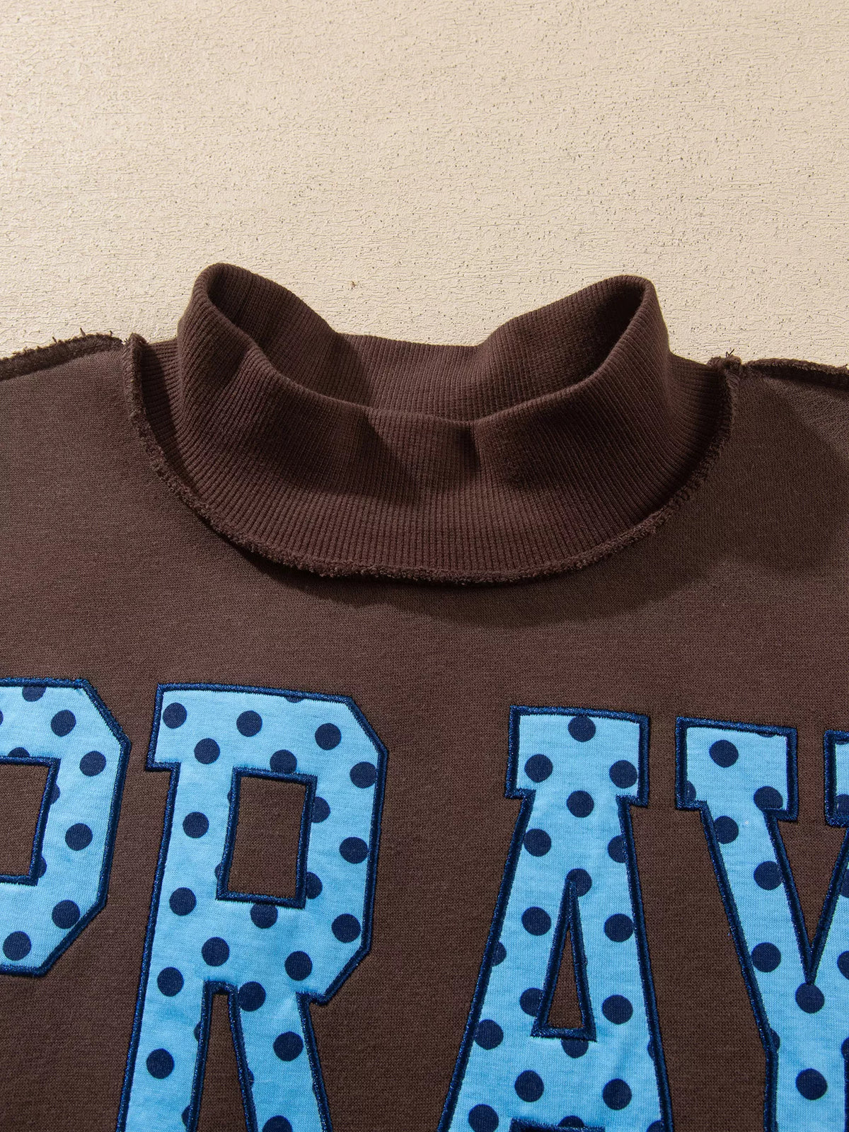 PRAY Polka Dot Embroidered Mock Neck Sweatshirt in dark brown, construction detail