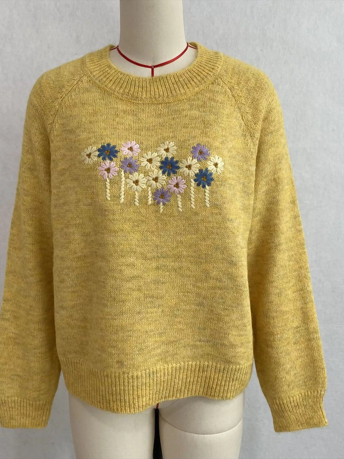 Floral embroidered round-neck sweater in yellow, front mannequin view